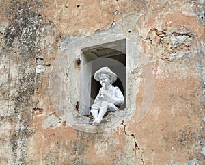 Sculpture, a boy playing the flute.