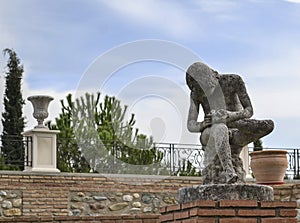Sculpture of a boy sitting while removing a thorn from the sole of his left foot in the Quinta Alegre Palace in Granada photo