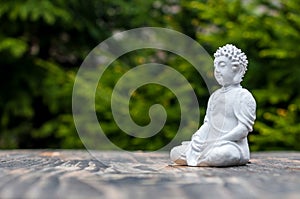 Sculpture of Buddha become enlightened on green background. Yoga and meditation concept