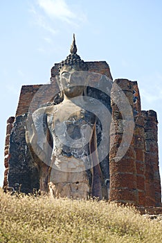 Sculpture of a Buddha on the ruins of an ancient Buddhist temple. Surroundings of Sukhothai, Thailand