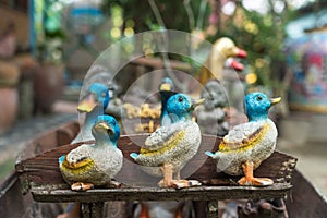 Sculpture of ceramic duck on wooden bench