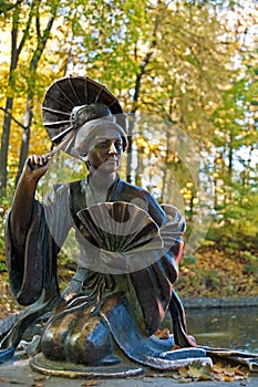 Sculpture of Chinese young woman with umbrella in Arboretum Oleksandriya in Bila Tserkva, Ukraine