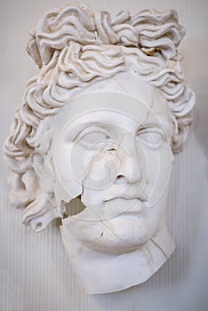 Sculpture of the face of a beautiful Greek woman, in cracks. Vertical frame