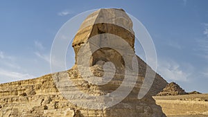 Sculpture of the great Sphinx against the blue sky and the pyramid of Menkaure