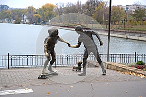 City panorama sculpture group skateboard lesson woman man dog calm lake