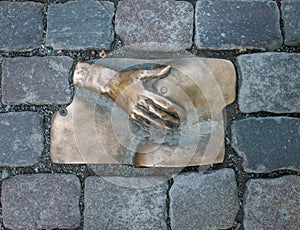 Sculpture of a hand holding a breast in bronze