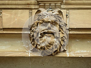 Sculpture of the head of a man on a facade of a house in Ostuni