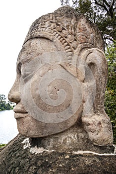 Sculpture of a huge stone male face with big earlobe, bridge of Angkor Thom, Angkor, Cambodia