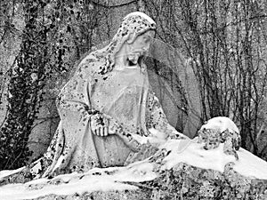 A sculpture of Jesus Christ and the deceased covered with a white blanket of snow in the Swiss settlement of Weesen - Switzerland