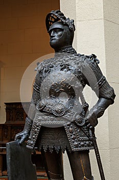 Sculpture of King Arthur old metal statue. Medieval knights armor full size standing warrior. Order of the Knights