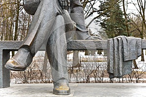 Sculpture legs sit on a park bench