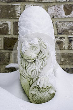 Sculpture of a lion covered with snow during a cold winter day