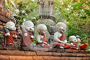 Sculpture of little monks with bowls at the buddhists temple in Ayutthaya