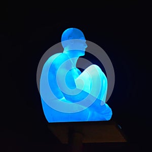 The sculpture of a man, illuminated by blue. Nice, France