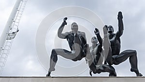 Sculpture Running with men runners monument on dramatic sky background. Running man or marathon runner.