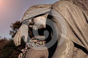 A sculpture of sad woman in grief. Stone statue faith, suffering, death concept