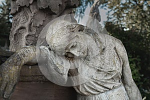A sculpture of sad woman in grief. Virgin Mary stone statue faith, suffering, death concept