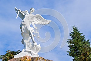 Sculpture of St. Michael the Archangel with sword and libra striking devil