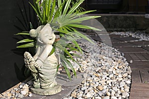 Sculpture thai girl doll in the pebble garden