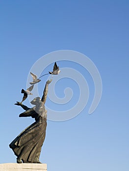 Sculpture woman with pigeons