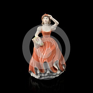 Sculpture of a woman in a red dress on a black background.