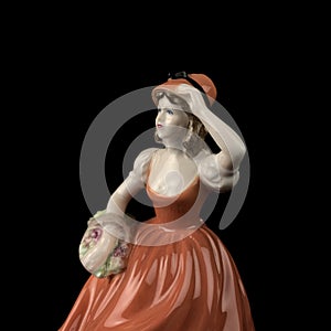 Sculpture of a woman in a red dress on a black background.