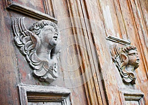 Sculpture of a wooden angel on a old italian door Italy - more than a hundred years old