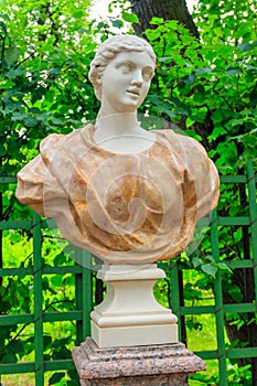 Sculpture of young woman in a pink drapery in old city park