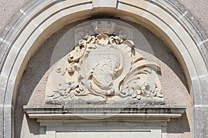 A sculptured blazon and plant motives decorate the facade of a building (France) photo