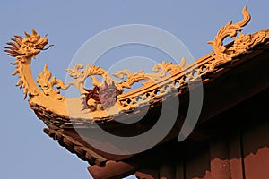 A sculptured dragon decorates the ridgepole of a buddhist temple in Hanoi (Vietnam)
