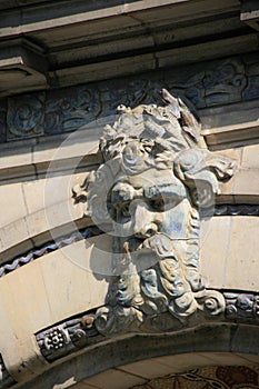 The sculptured head of an old man decorates the facade of a building (France) photo