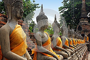 Sculptures of Buddha sitting in meditation at Wat Yai Chaimongkol temple in Ayutthaya, Thailand.