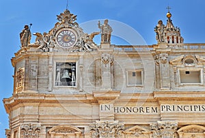 Sculptures and clock on the facade of Saint Peter basilica