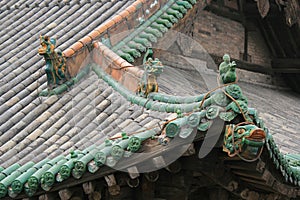 Sculptures of fantastic animals and glazed tiles decorate the roof of a temple (China)