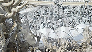 Sculptures of human hands sticking out of the ground, like from the hell. Wat Rong Khun.