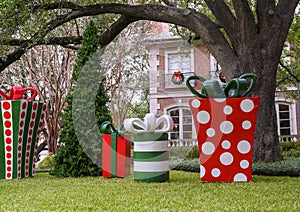 Sculptures of large Christmas gifts with bows and an undecorated Christmas tree before a mansion in Highland Park, Dallas, Texas photo