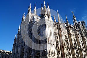 Sculptures and spires of the Cathedral, partial view at an angle of the front and side exterior, Milan, Italy