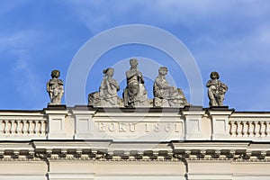 Sculptures at the top of the building on the Krakowskie Przedmiescie street, Warsaw, Poland photo