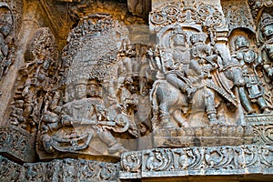 Sculptures on the west side walls. Ravana lifting Kailasa on the left and Shiva-Parvati on Nadi on the right. Hoysaleshwara temple