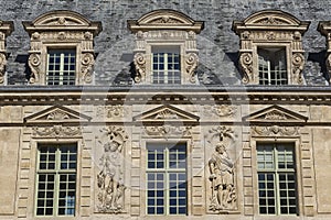 Sculptures and windows on HÃ´tel de Sullyâ€™s faÃ§ade