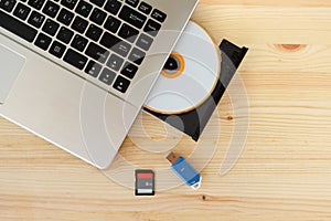 SD Card, Flash Drive USB3.0 and CD DVD Drive Writer Burner Reader of laptop computer on wooden background