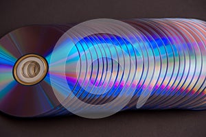 sd and dvd disks on a dark background. large stack.