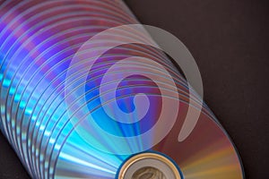 sd and dvd disks on a dark background. large stack.