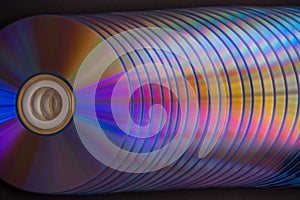 sd and dvd disks on a dark background. large stack.