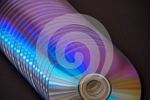 sd and dvd disks on a dark background. large stack.