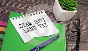 SDLT - Stamp Duty for Land Tax is written on a notebook on a green background