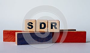SDR - acronym on wooden cubes on a background of colored block on a light background