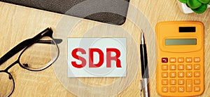 SDR text on a background on wooden cubes on a light table isolated