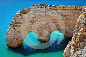 Sea arch and turquoise water of Atlantic Ocean in Praia da Marinha beach in Algarve, Portugal