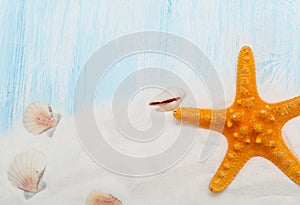 Sea background with white sand and blue painted wood, starfish, shells